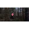 Young woman running outdoors in a forest, going fast (motion blurred image)