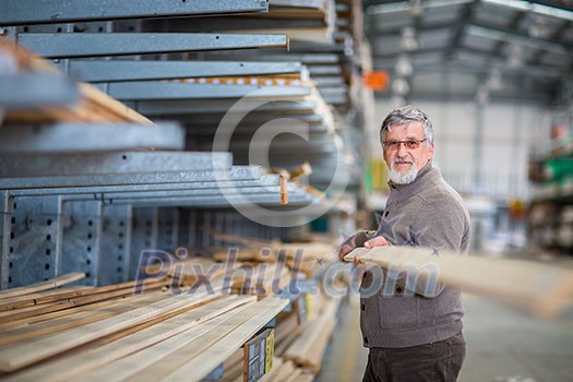 DIY concept -Senior man choosing and buying construction wood in a DIY store for his DIY home re-modeling project DIY concept -Senior man choosing and buying construction wood in a DIY store for his DIY home re-modeling project