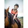 Cute young girl riding a horse