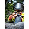 Female hiker/climber preparing supper on gas burner in a camp