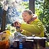 Female hiker/climber preparing supper on gas burner in a camp