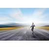 Young businessman in suit running on asphalt road