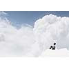 Smiling young businessman sitting alone on cloud high in sky