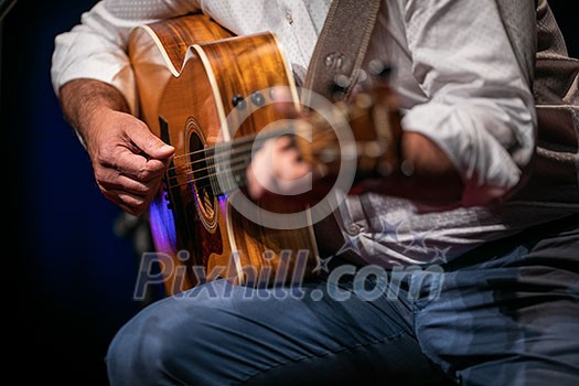 Man playing a guitar on stage (shallow DOF; color toned image) Man playing a guitar on stage (shallow DOF; color toned image)