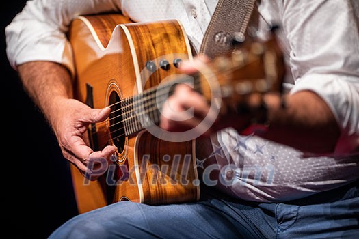 Man playing a guitar on stage (shallow DOF; color toned image) Man playing a guitar on stage (shallow DOF; color toned image)