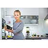 Pretty, young woman cooking in her modern kitchen