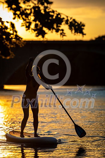 SUP Stand up paddle board concept - Pretty, young woman paddle boarding on a lovely lake in warm late afternoon light - shot from underwater SUP Stand up paddle board concept - Pretty, young woman paddle boarding on a lovely lake in warm late afternoon light - shot from underwater