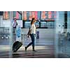 Young woman with her luggage at an international airport, before going through the check-in and the security check before her flight