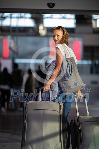 Young woman with her luggage at an international airport, before going through the check-in and the security check before her flight