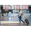 Young woman with her luggage at an international airport, before going through the check-in and the security check before her flight