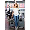 Young woman with her luggage at an international airport, before going through the check-in and the security check before her flight