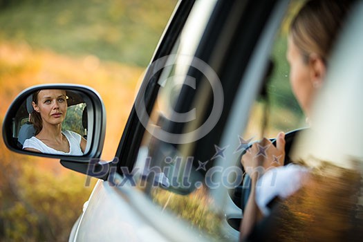 Pretty, young woman  driving her car - reflection in the side mirror (shallow DOF; color toned image)
