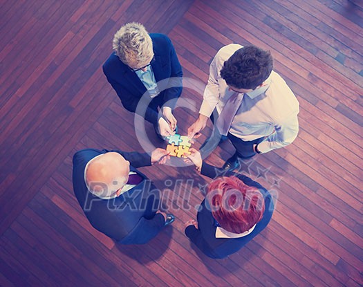 business people group assembling jigsaw puzzle and represent team support and help concept, top view perspective at modern bright office interior business people group assembling jigsaw puzzle and represent team support and help concept, top view perspective at modern bright office interior
