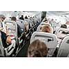 Interior of commercial airplane with passengers in their seats during flight.