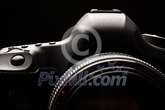 Professional modern DSLR camera low key image - Modern DSLR camera with a very wide aperture lens on Professional modern DSLR camera low key image - Modern DSLR camera with a very wide aperture lens on