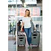 Young woman with her luggage at an international airport, before going through the check-in and the security check before her flight