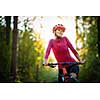 Pretty, young woman biking on a mountain bike enjoying healthy active lifestyle outdoors in summer (shallow DOF)