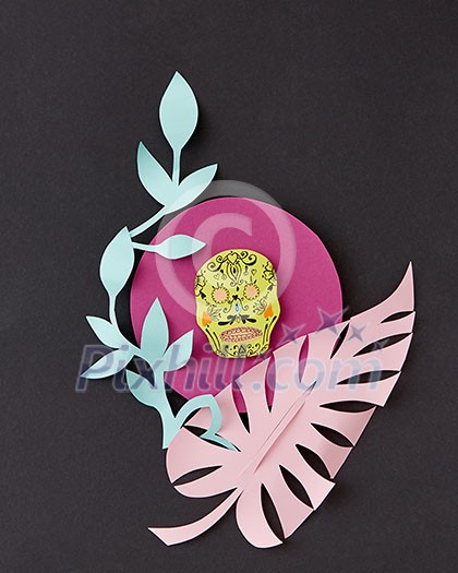 Greeting handcraft card with paper palm leaves and creative skull on a pink frame on a black background, place for text.The national Mexican holiday of Calaka. Flat lay Greeting handcraft card with paper palm leaves and creative skull on a pink frame on a black background, place for text.The national Mexican holiday of Calaka. Flat lay