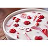 Fresh delicious homemade breakfast of fresh yogurt with berries in a ceramic white bowl on a wooden background. Soft focus.