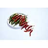 A composition of red and green chili peppers on a white plate isolated on a white background.