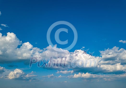 White fluffy clouds in the blue sky at sunset in the summer day. Nature weather, cloudy blue sky.