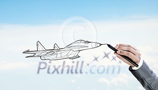 Person drawing airplane model on sky background Person drawing airplane model on sky background