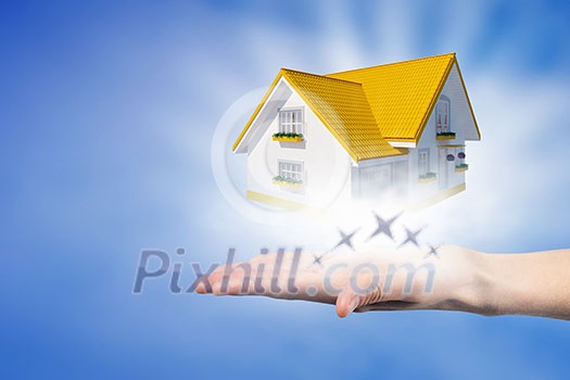 Human hands holding model of dream house Human hands holding model of dream house