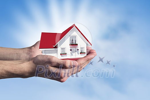 Human hands holding model of dream house Human hands holding model of dream house
