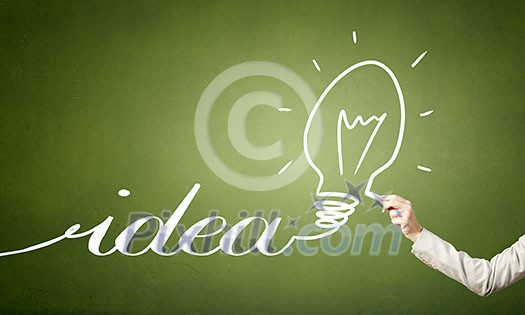 Human hand darwing light bulb as idea concept with chalk Human hand darwing light bulb as idea concept with chalk