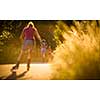 Young woman running outdoors on a lovely sunny summer evening (shallow DOF; color toned image)