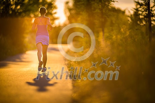 Young woman running outdoors on a lovely sunny summer evening (shallow DOF; color toned image)