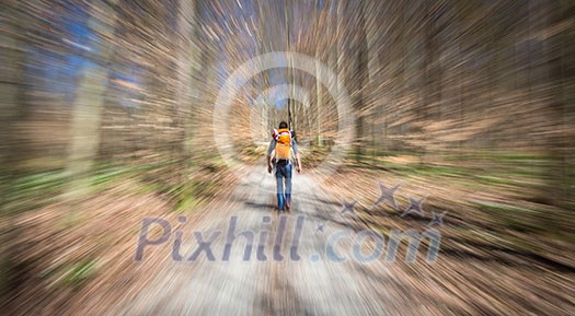 Traveler hiking through deep forest in the mountains - blurred motion techique used to convey fast paced movement