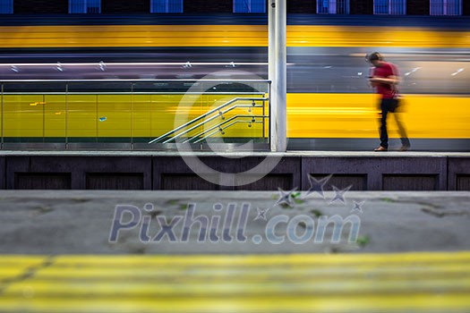 Pepople in a trainstation with motion blurred trains moving fast (color toned image)