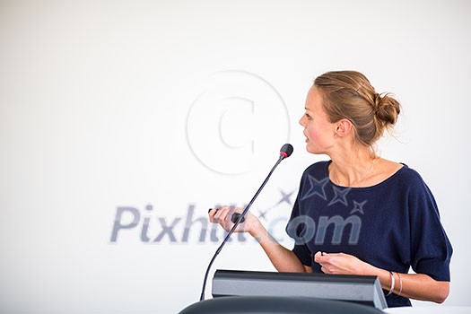 Pretty, young business woman giving a presentation in a conference/meeting setting (shallow DOF; color toned image)