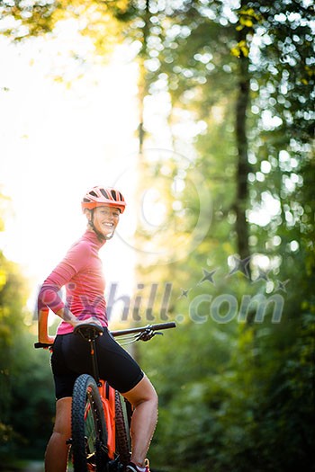 Pretty, young woman biking on a mountain bike enjoying healthy active lifestyle outdoors in summer (shallow DOF) Pretty, young woman biking on a mountain bike enjoying healthy active lifestyle outdoors in summer (shallow DOF)