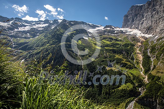 Pretty, female climber on a via ferrata - climbing on a rock in Swiss Alps