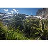 Pretty, female climber on a via ferrata - climbing on a rock in Swiss Alps