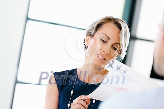 Female manager assessing work of her employees Female manager assessing work of her employees