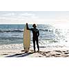 A surfer with his surfboard at the beach