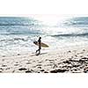 A surfer with his surfboard at the beach