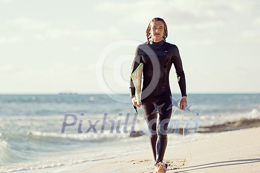 A surfer with his surfboard at the beach