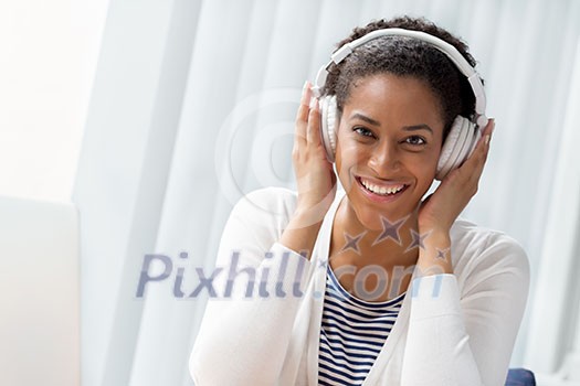 Woman in headphones sitting at desk in office Woman in headphones sitting at desk in office