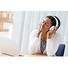 Woman in headphones sitting at desk in office