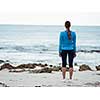 Sporty young woman standing in front of the ocean