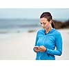 Sporty young woman with earphones on the sea coast