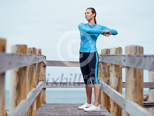 Sporty young woman stretching next to the sea coast Sporty young woman stretching next to the sea coast