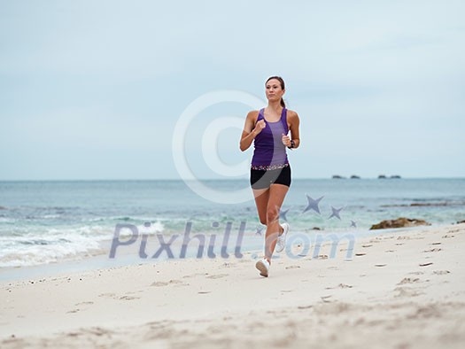 Sporty young woman running on the sea coast Sporty young woman running on the sea coast