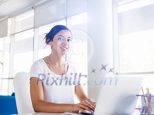 Young woman working with a laptop in office Young woman working with a laptop in office