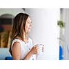 A young woman having coffee in office