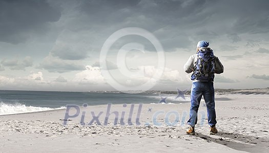 Male tourist with backpack walking outdoor. Mixed media